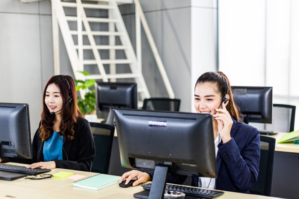 Customer service agents working at computers in an office with headsets.