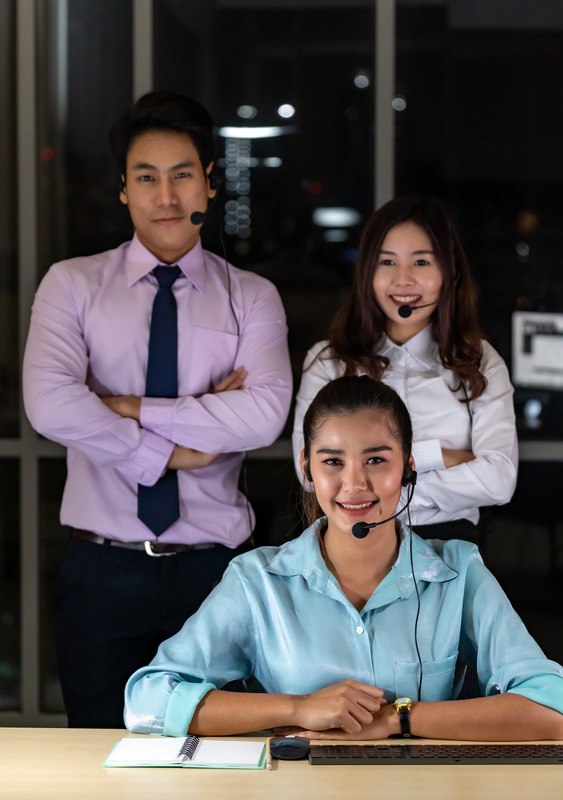 Late Night Environment, Potrait of friendly Call centre operator team with headsets in a call center customer service and technical support. Using for 24 Hr. Call center Concept.