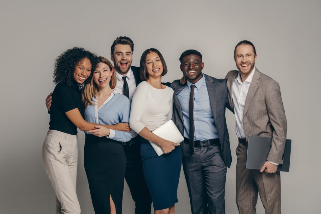 Smiling multicultural business team posing together in a studio.